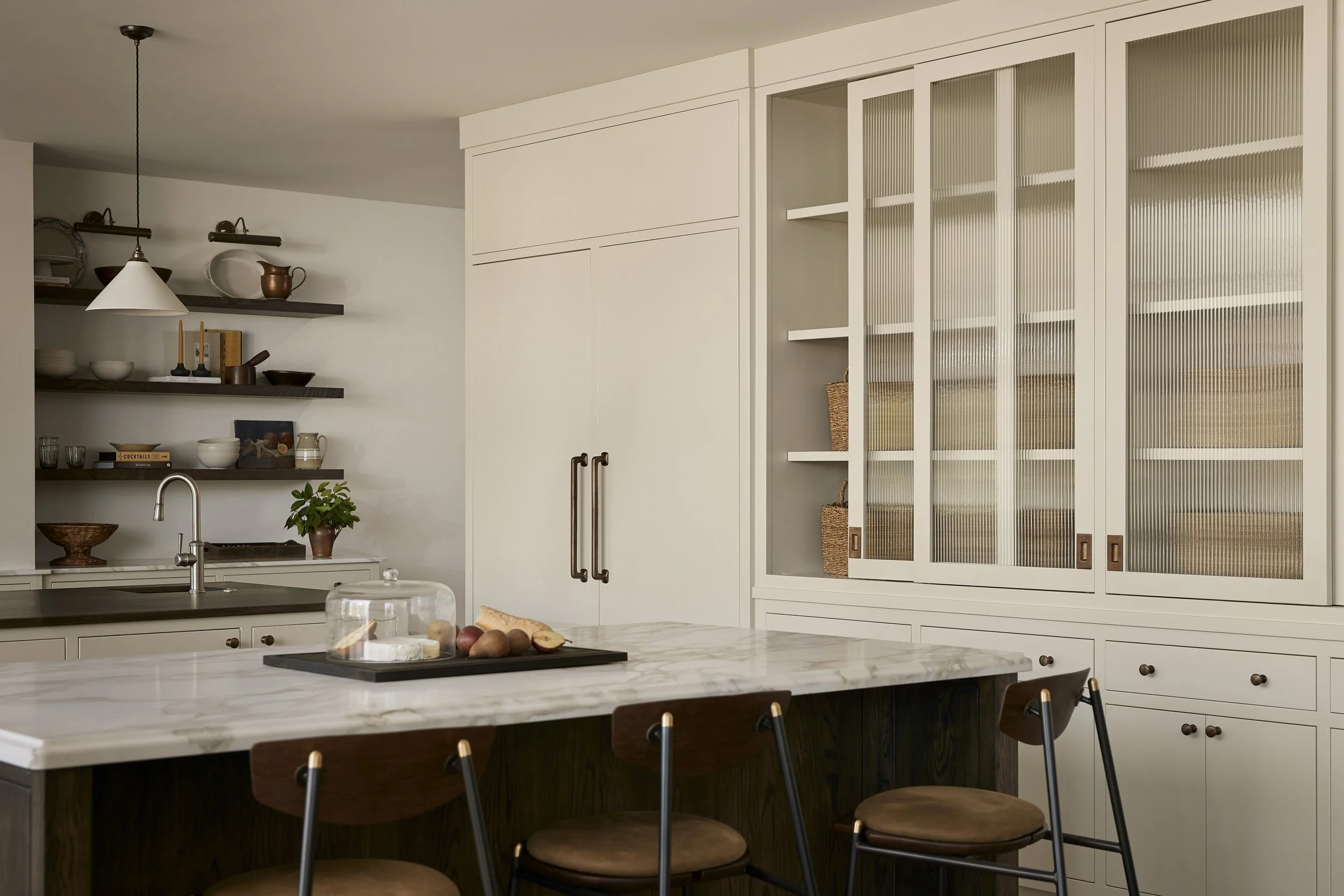 Kitchen detail showing walnut wood and Calacatta marble with plaster range hood