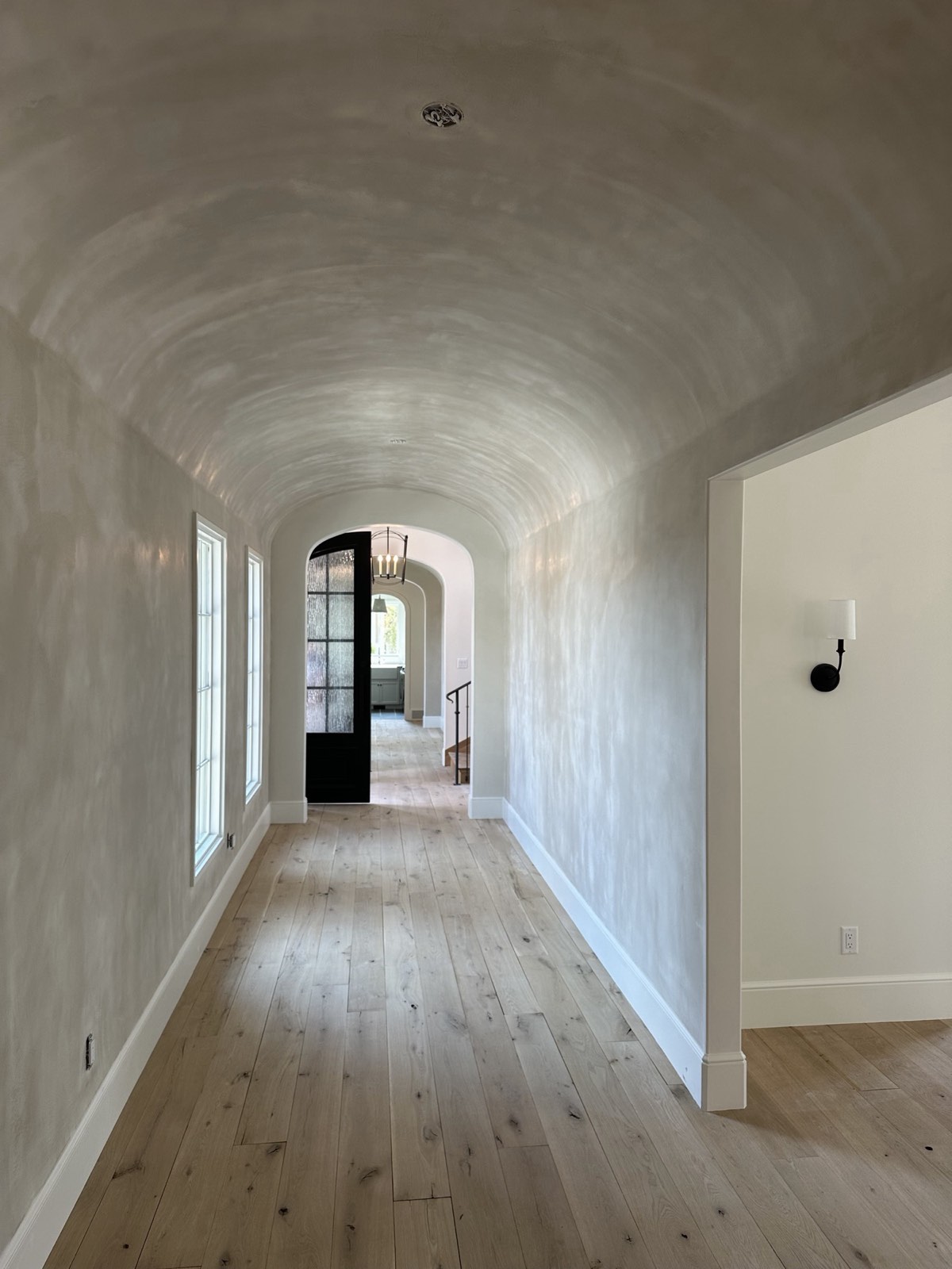 Barrel-vault hallway with plaster on the walls and curved ceiling