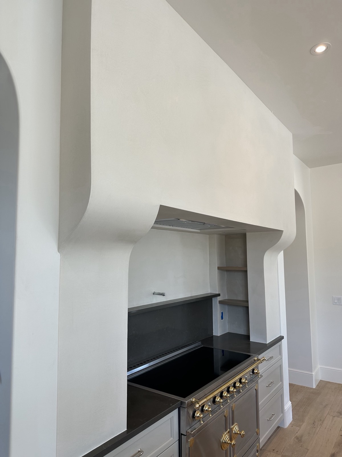 Side view of a curved plaster range hood